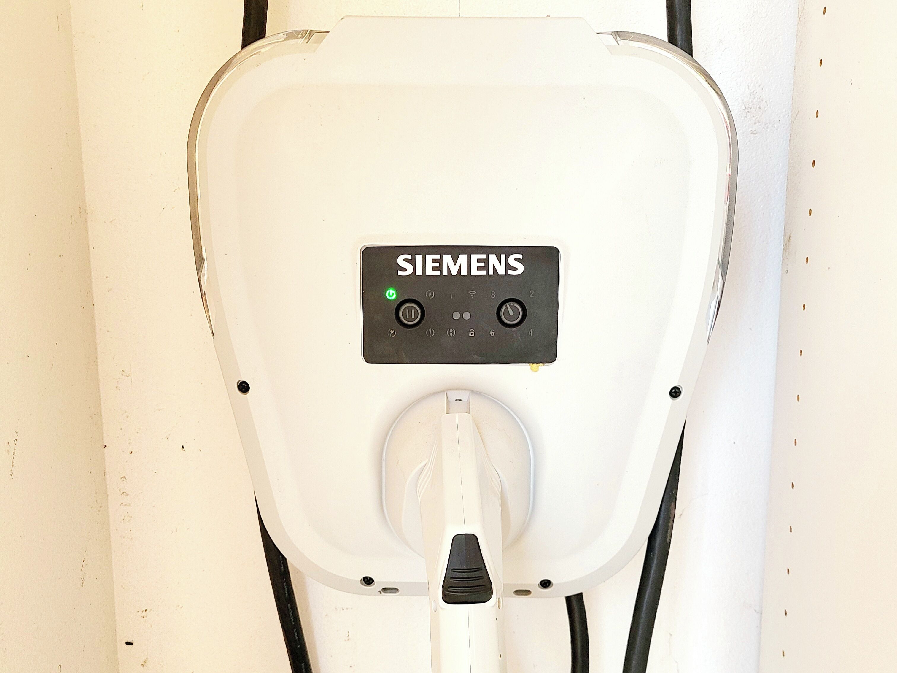Een Siemens laadstation voor elektrische voertuigen, met een stekker en bedieningspaneel.