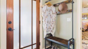 A room with a wooden door, a bench with a hat rack, and a bed with a striped blanket. - Views, King bed, EV charger, 5 min to Downtown (Paso Robles)