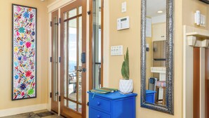 A hallway with a blue cabinet, a large mirror, and a colorful abstract painting. - Views, King bed, EV charger, 5 min to Downtown (Paso Robles)