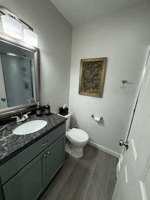 A bathroom with two sinks, a toilet, and a shower.