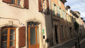 Una hilera de edificios con puertas y ventanas de arco, algunas con contraventanas.