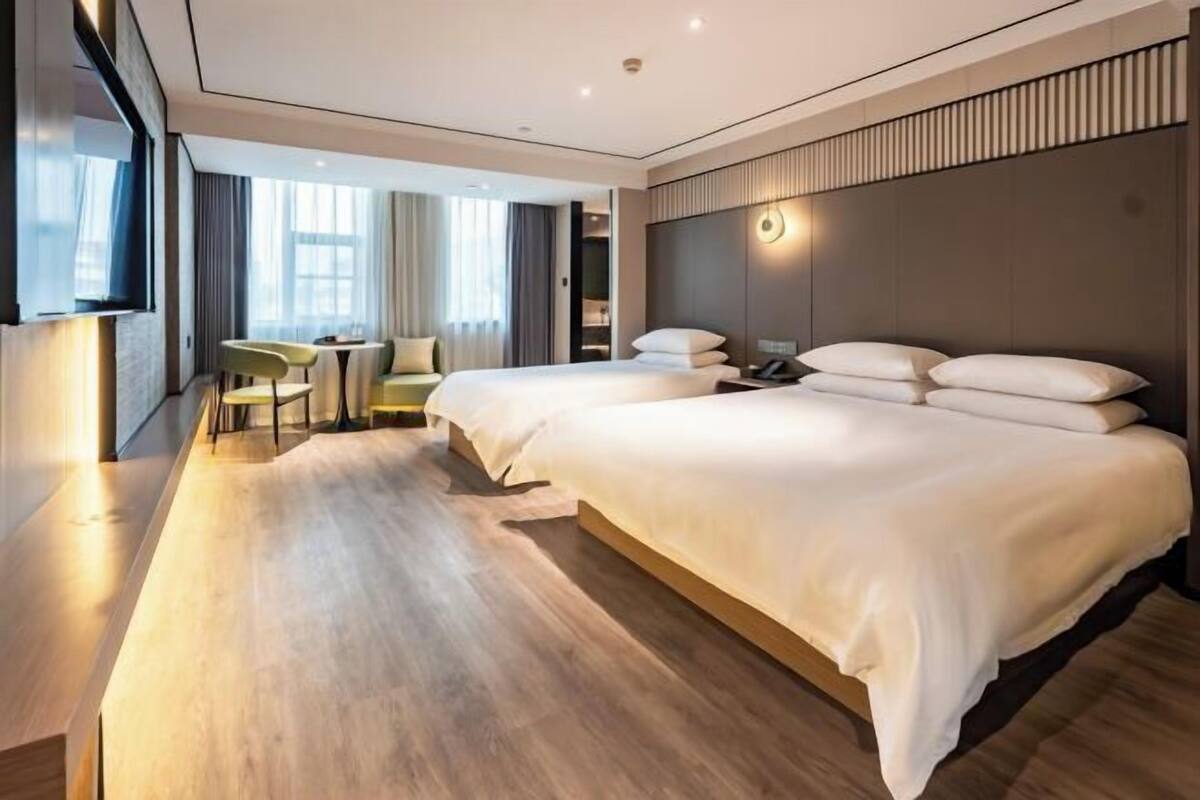 Une chambre d’hôtel moderne, dotée d’un grand lit, d’un bureau et d’une chaise.