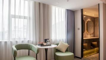 Relax in a serene space with a large window, round table, and comfortable chairs.