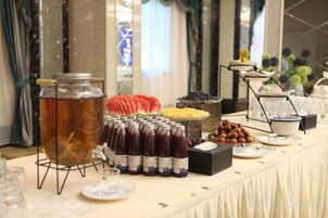 Una mesa de buffet con una variedad de alimentos y bebidas.