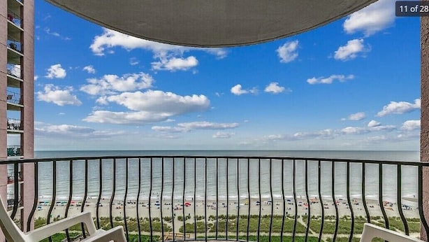 A balcony with a view of a beach and ocean.