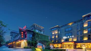 A hotel with multiple floors, a well-lit entrance, and a visible signboard.