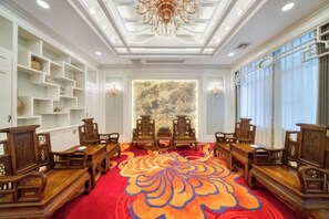 A room with a traditional wooden furniture arrangement, a patterned carpet, and a chandelier. - Ningbo Ninghaixia Guesthouse Hotel (Xuxiake Avenue Branch) (Ninghai)