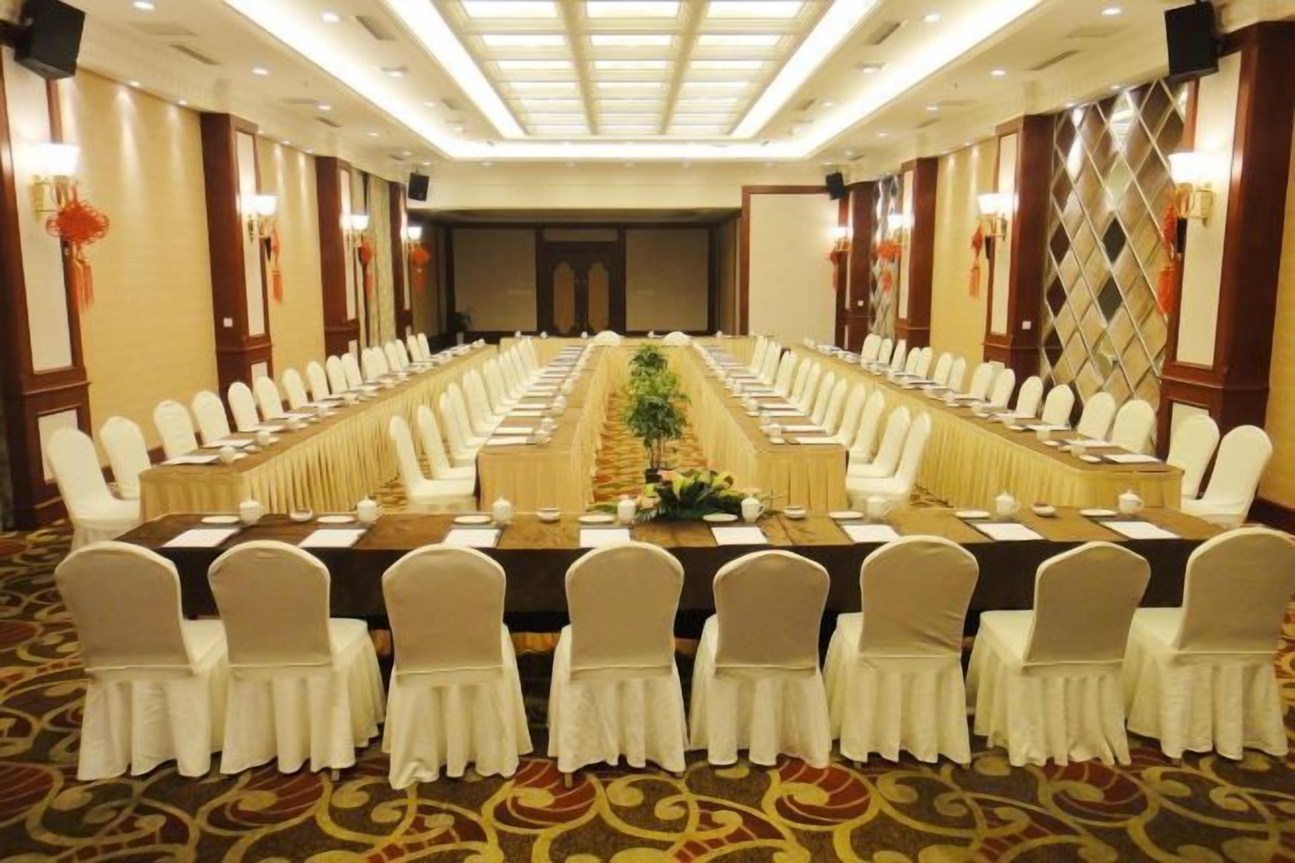 A conference room with a long table, multiple chairs, and a carpeted floor.