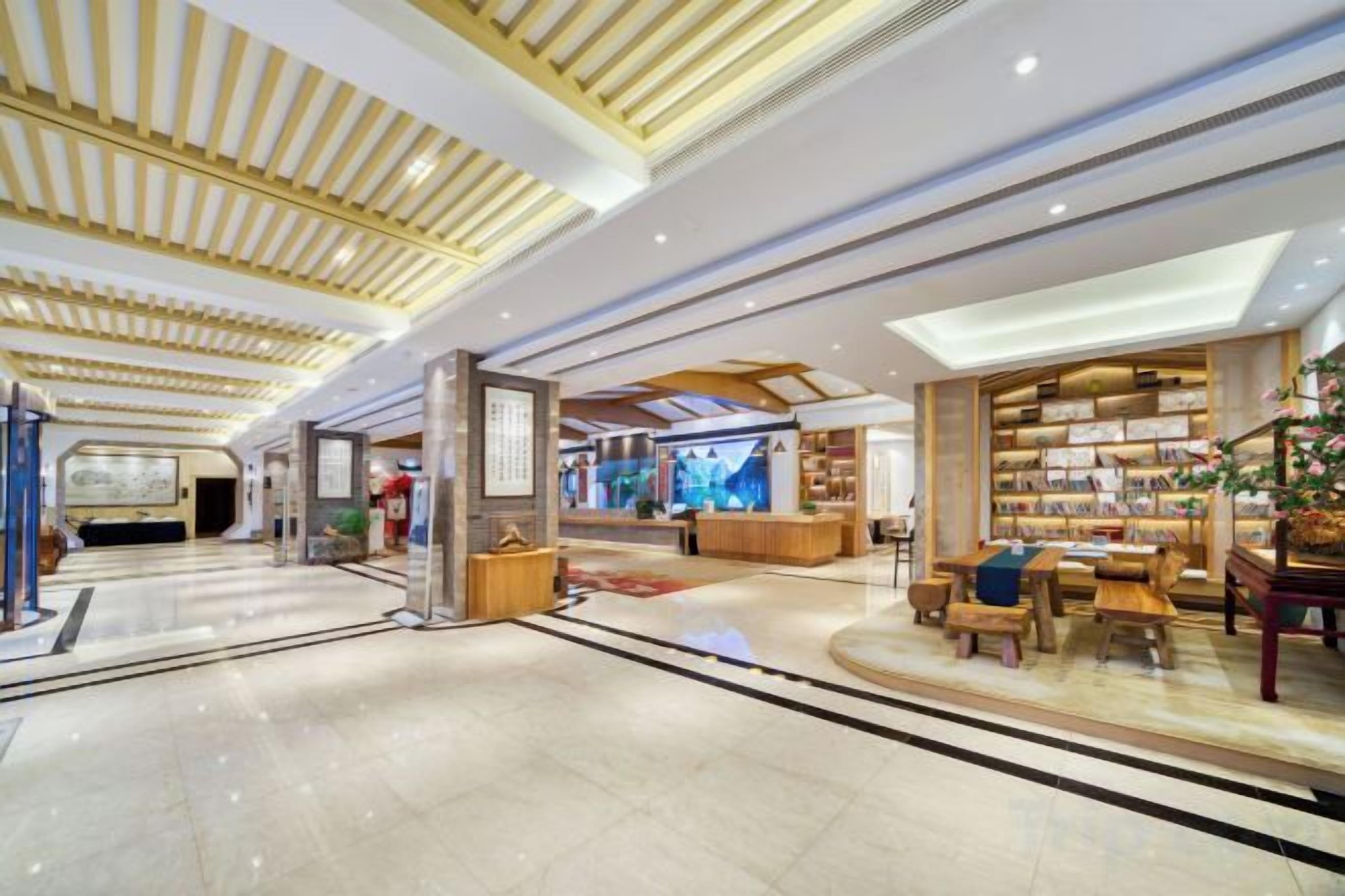 A spacious lobby with a high ceiling, a reception desk, and a seating area with a coffee table.