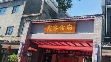 A building with a sign that reads 'Hospitality Restaurant' and a digital display with text.