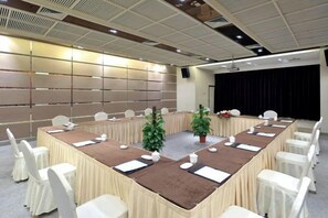 A conference room with a long table, white chairs, and a projector screen. - Ningbo Ninghaixia Guesthouse Hotel (Xuxiake Avenue Branch) (Ninghai)