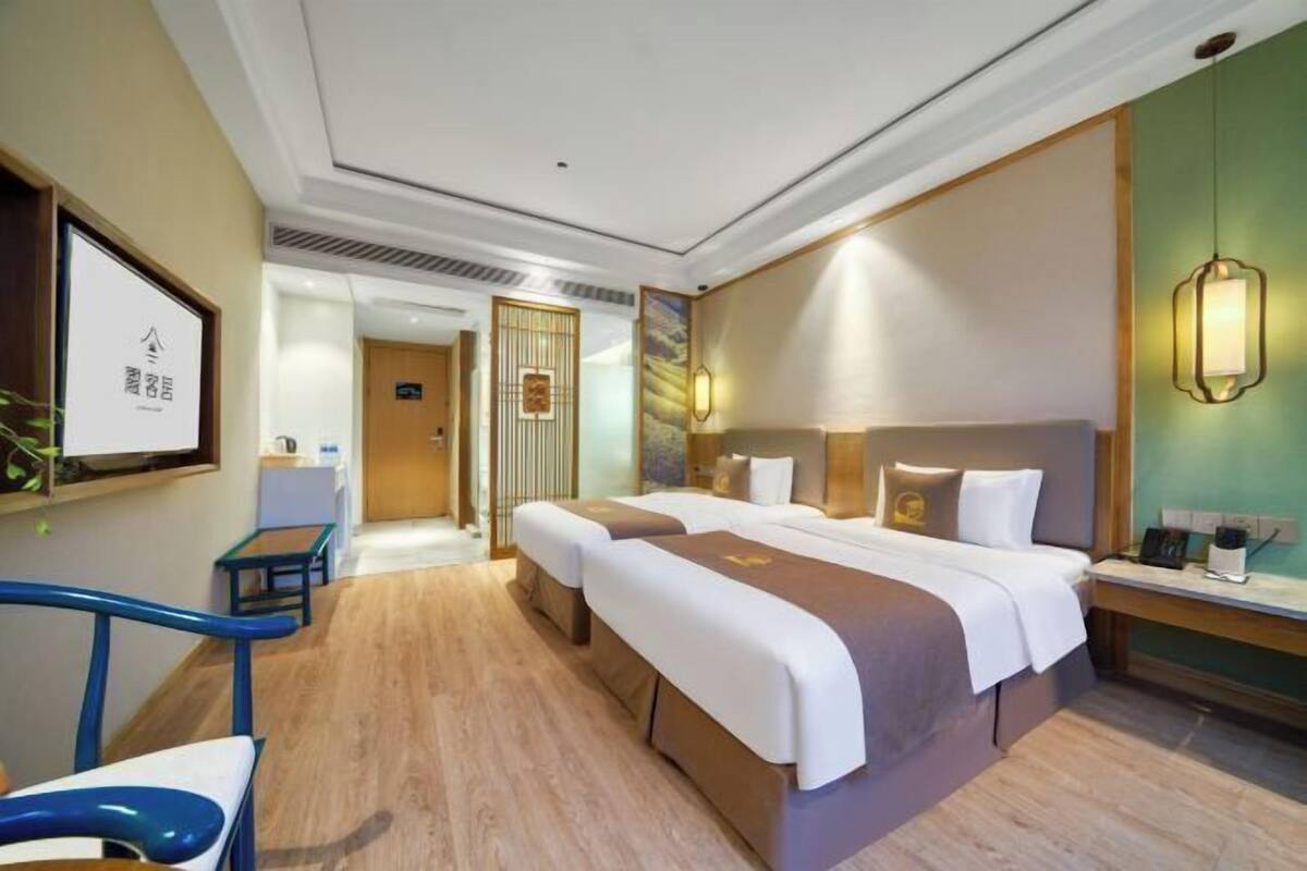 A hotel room with a double bed, bedside tables, a desk, and a chair.