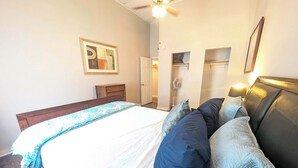 A bedroom with a bed, a ceiling fan, a wardrobe, and a door leading to a bathroom. - Chapel Summary:<br>🏡 Wel (Ingleside)