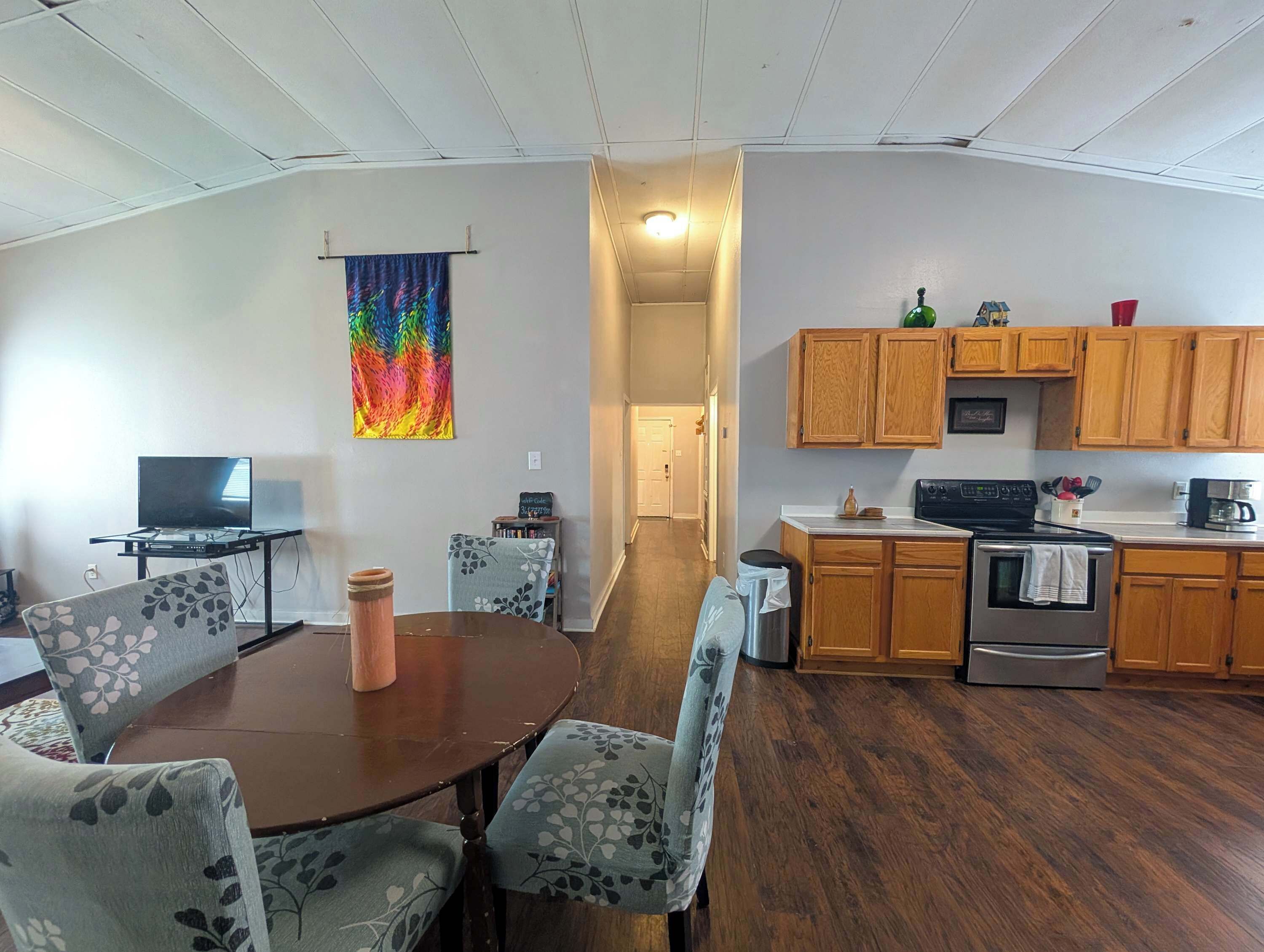 A compact living space with a dining area, a kitchen, and a hallway.