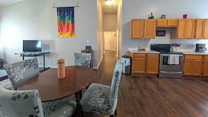 A compact living space with a dining area, a kitchen, and a hallway. - Chapel Summary:<br>🏡 Wel (Ingleside)