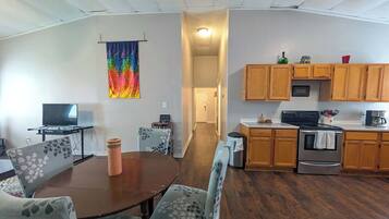 A compact living space with a dining area, a kitchen, and a hallway.