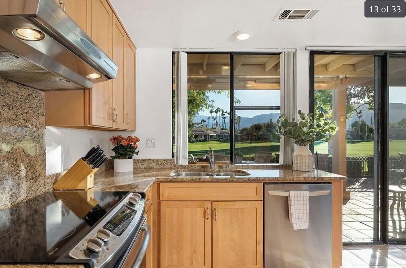 A modern kitchen with granite countertops, wooden cabinets, and a built-in oven.