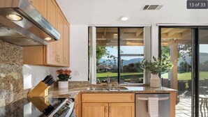A modern kitchen with granite countertops, wooden cabinets, and a built-in oven.