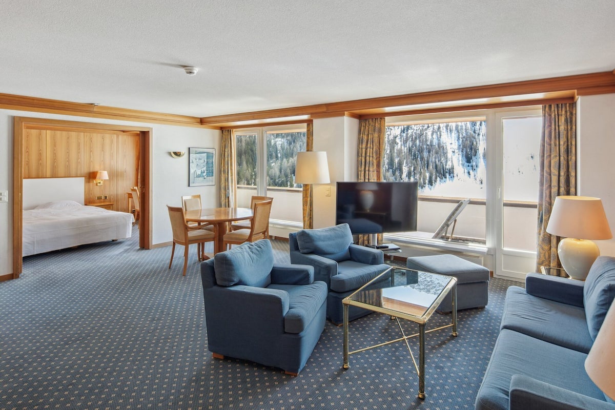 Suite Deluxe, balcón, vista a la montaña | Área de sala de estar | Televisión de pantalla plana de 42 pulgadas con canales vía satélite