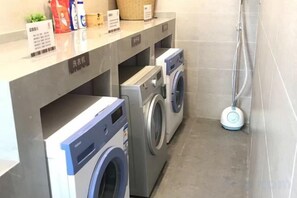 A laundry area with washing machines and a hose. - Home Inn Select (Shanghai Zhoupu Wanda Plaza Branch) (Shanghai)