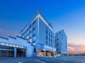 Un hôtel moderne, reconnaissable à son grand panneau « BORRMAN », à ses grandes fenêtres et à son parking.