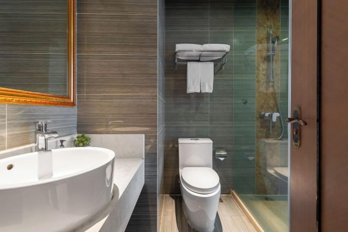 A modern bathroom with a freestanding bathtub, a toilet, and a glass-enclosed shower area.