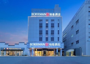 A hotel building with a prominent sign reading 'BORRMAN' and '柏曼酒店'.