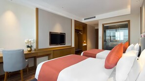 Una camera d'albergo con un letto, una scrivania, una televisione e vista sull'esterno.