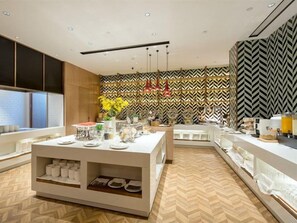 Una cucina moderna con isola centrale, elettrodomestici integrati e una parete rivestita con decorazioni.