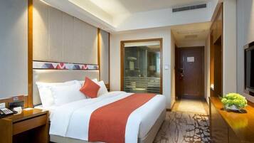 Ein Hotelzimmer mit Bett, Nachttisch und Fernseher.