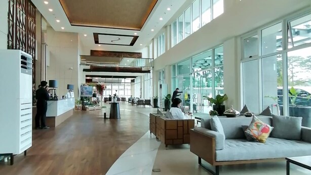 A spacious lobby with a wooden floor, a reception desk, and a seating area with a sofa and armchairs. - Condo 604, w/ Pool & Gym & Minutes to Baguio city Attractions (2600 Baguio City)