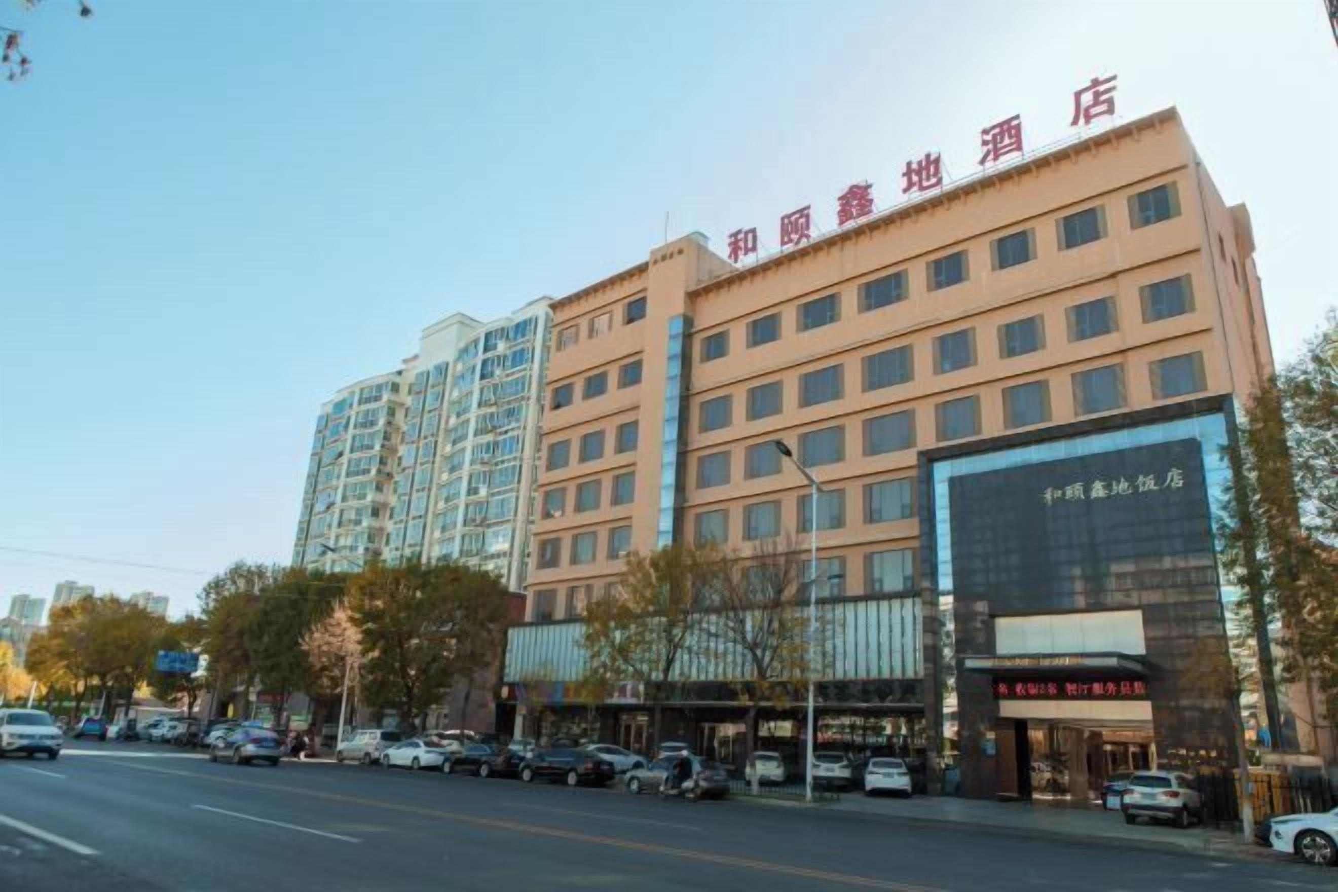 A hotel with multiple floors, a large glass facade, and a sign indicating it is a hotel.