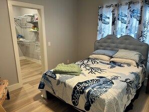 A bedroom with a bed, a nightstand, and a wardrobe. - 4-bedroom house on Lake Wawasee with a stunning, screened in porch! (Syracuse)