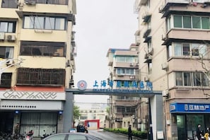 A multi-story building with a sign indicating a hotel entrance. - Changee Hotel (Shanghai Baoshan Wanda Gongkang Road Subway Station) (Shanghai)