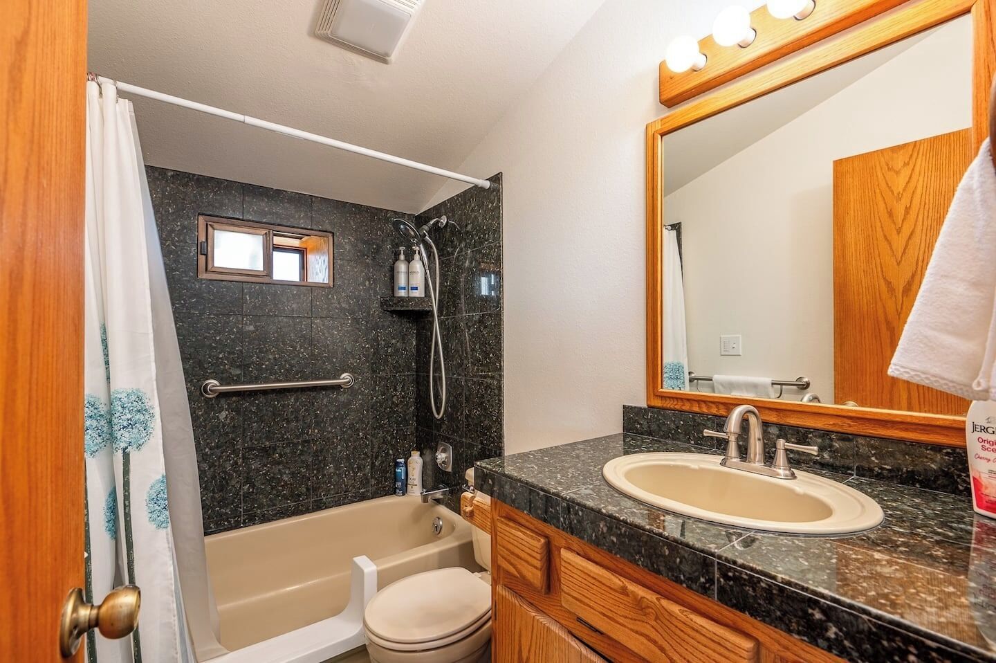 A bathroom with a bathtub, a sink, a mirror, and a shower.