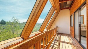 A wooden balcony with a view of a green landscape. - Sundance Ranch Retreat | Hot Tub • Cascade Views (Deschutes County)