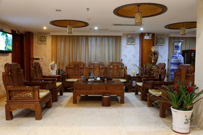 A traditional living room with wooden furniture, a television, and decorative items.