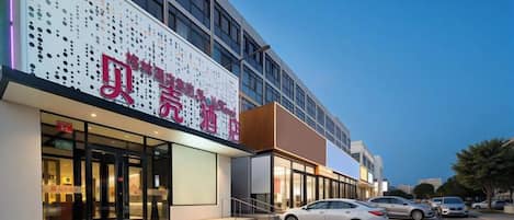 A hotel with a modern facade, large windows, and a visible entrance.