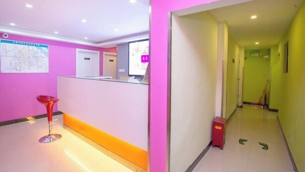 A brightly colored reception area with a map on the wall, a reception desk, and a red stool. - 100 Inn (Shanghai Jiangpu Road Metro Station) (Shanghai)