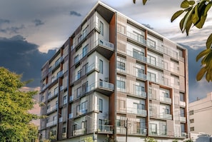 Un immeuble résidentiel à plusieurs étages, doté de balcons, de grandes fenêtres et d’une architecture moderne.