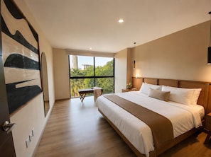 Ein Schlafzimmer mit großem Fenster, einem Bett, einem Nachttisch und einer Bank.