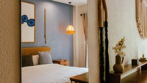 Une chambre à coucher comprenant un lit, une table de chevet, une lampe et des éléments décoratifs sur les murs.