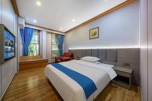 Une chambre d’hôtel avec un lit, une télévision, un bureau et une chaise.