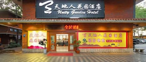 A hotel with a prominent signboard, a tiled entrance, and a welcoming entrance area.