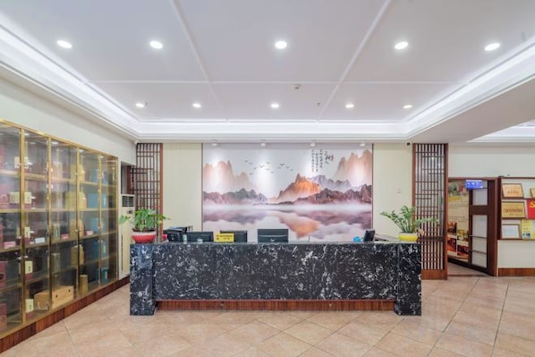 A reception area with a marble counter, a large wall mural, and a glass display cabinet.