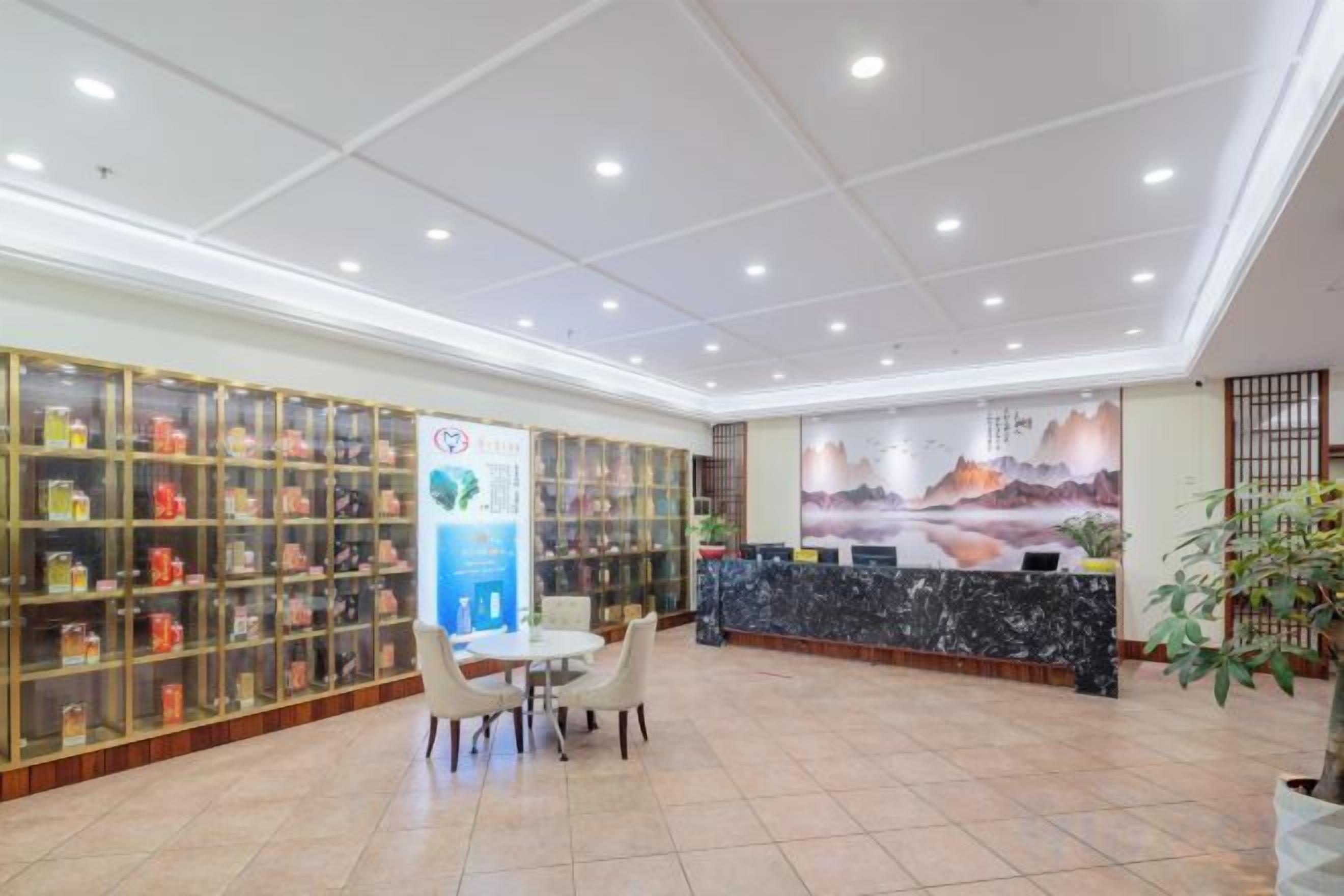 Un vestíbulo de hotel con recepción, zona de estar y vitrinas.