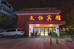 A hotel entrance with a red facade and illuminated signage. - Wenxie Hotel (Hangzhou)