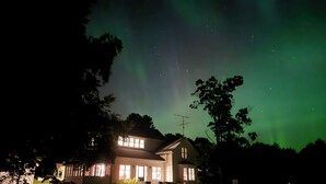 Una casa con un porche iluminado y una antena visible.