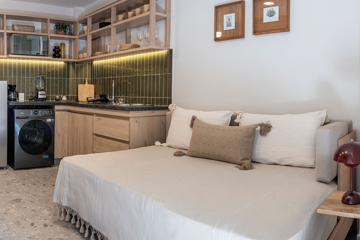 Ein kleines Schlafzimmer mit Bett, Nachttisch und einem kleinen Arbeitsbereich.