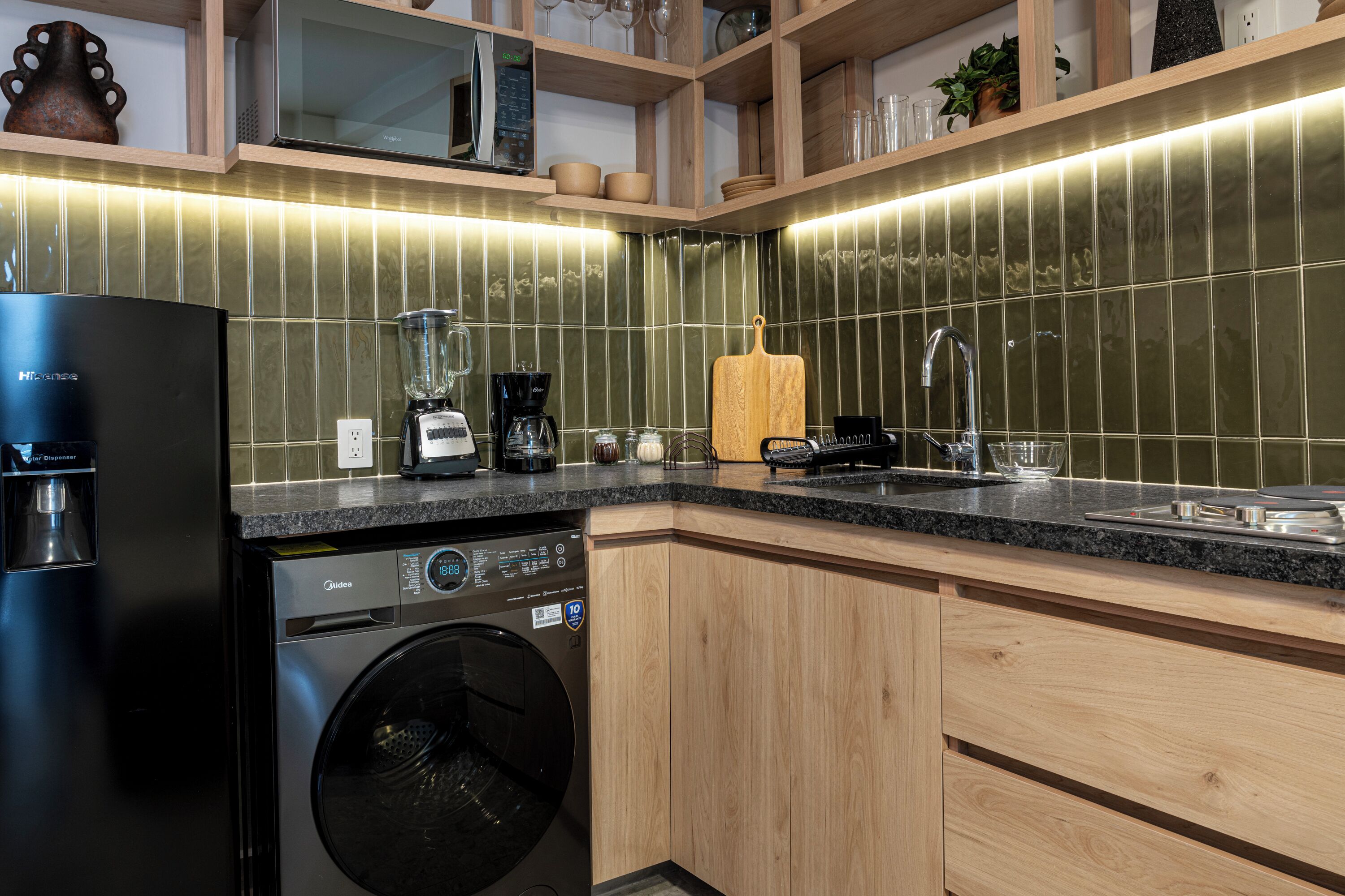 Una cocina moderna equipada con lavavajillas, cafetera y lavabo.
